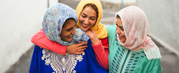 Happy Muslim women walking in the city center - Arabian young girls having fun spending time and...