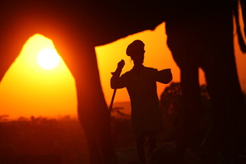 a camel and a man at sunset at Pushkar Camel Fair