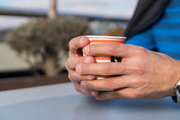 Male hand holding paper cups