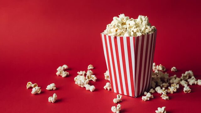 Striped box with popcorn on red background