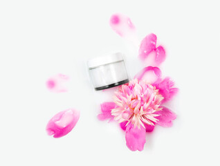 Cream and peony flower in a bath with milk. Gentle care. Conceptual photo: the best cosmetic tool for body and face care. Natural cosmetics, mock up.