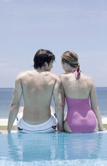 Man and woman sitting by the poolside