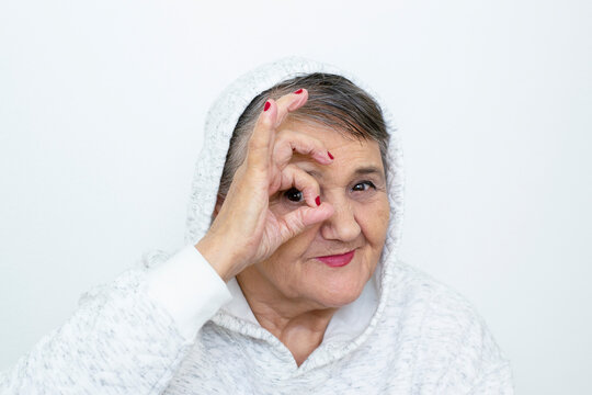 Funny grandma's portraits. The old lady makes a hipster the hand gestures. Fashion hipster woman having fun. Funny moments with a granny woman. Lifestyle and people concepts