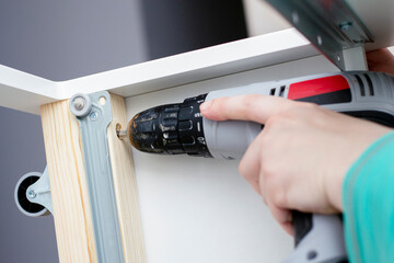 Assembly of furniture. The young man tries to assemble the furniture according to the instructions.