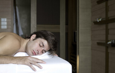 Man lying on massage table with his eyes closed