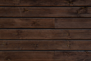 Medium brown wood texture backviewed from above. The wooden planks are stacked horizontally and have a worn look.