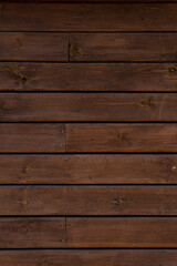Medium brown wood texture backviewed from above. The wooden planks are stacked horizontally and have a worn look.