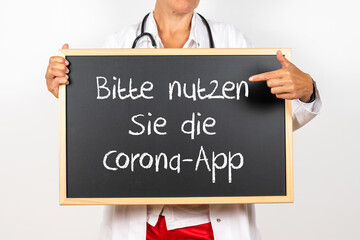 Arzt mit einer Tafel Bitte nutzen Sie die Corona App
