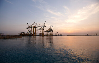 Fototapeta na wymiar Cranes in seaport at sunrise.