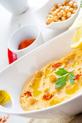 hummus paste with lemon and chilli on white background