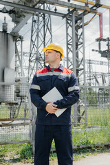 The energy engineer inspects the equipment of the substation. Power engineering. Industry.