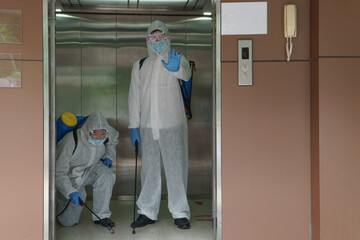 Men in protective clothing sprayed to disinfect contaminated areas