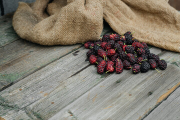 Mulberry isolated on a wooden background. Ripe mulberry fruit. Healthy food from mulberry fruit has...