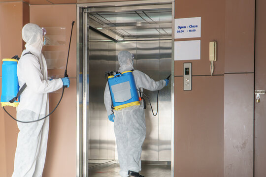 Men in protective clothing sprayed to disinfect contaminated areas