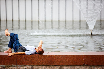 Man relaxing near the fountain in the park.