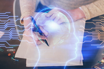 Double exposure of writing hand on background with brain hologram. Concept of learning.