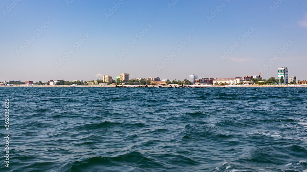 Wall mural View of buildings in the city near the beach with a blue sky background