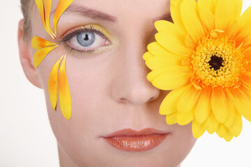 Woman with flower petals decorating her face
