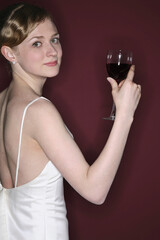 Woman in wedding gown with a glass of red wine