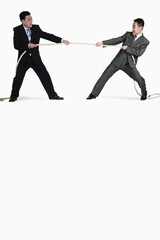 Businessmen playing tug of war