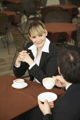 Business people chatting while enjoying cups of coffee