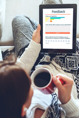Young woman writes a customer review and leaves rating on the tablet. Customer experience  and...