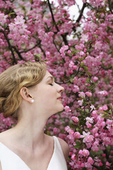 Woman in wedding enjoying the scent of flowers