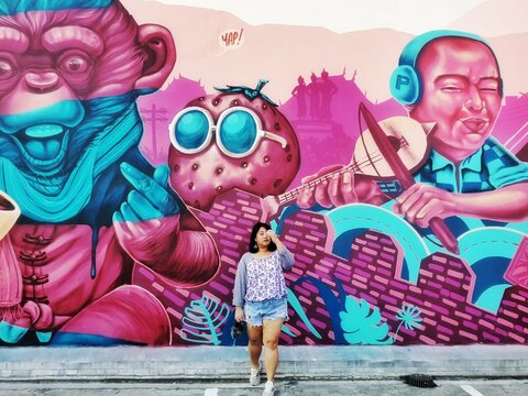 Full Length Of Woman Walking Against Graffiti Wall