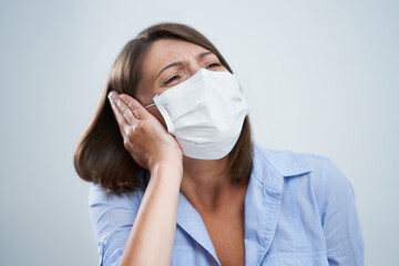 Attractive woman wearing protective mask isolated over white background