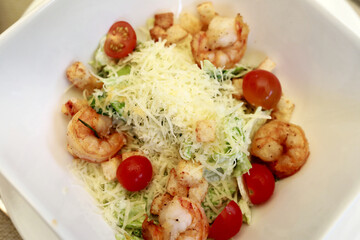 Caesar salad with shrimp on white plate
