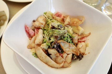 Salad with squid on white plate