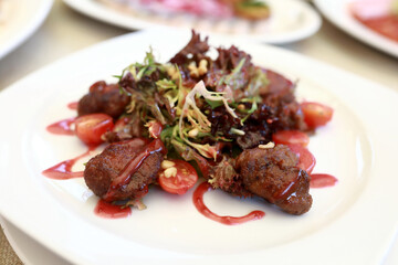 Warm salad with chicken liver on plate