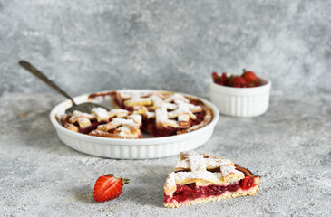 Cake with cherries and icing sugar on a concrete background. Sliced Cherry Pie.
