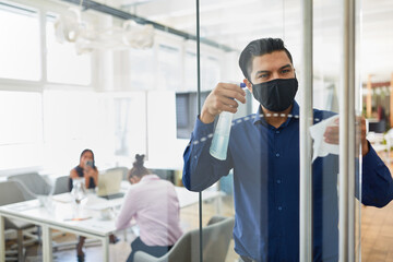 Business Mann mit Putzmittel bei der Flächendesinfektion