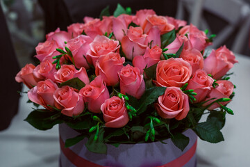 gift bouquet of fresh half-opened pink roses in a purple box. Image with selective focus