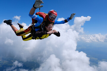 Skydiving. Tandem jump.  Happy girl and her instructor are flying in the sky.