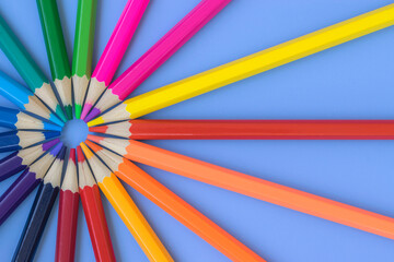 Colored pencils are laid out with rainbow colors. Goods for study and development. Art. 