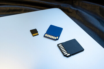 blue and black memory cards on silver laptop surface, close-up. concept of memory, information...
