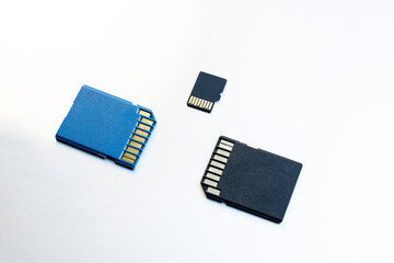 Three micro SD memory cards on gray background. blue and black memory cards for digital files, flat...