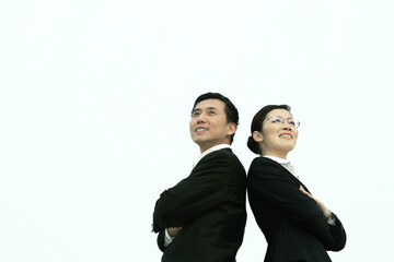 Businessman and businesswoman smiling while looking away