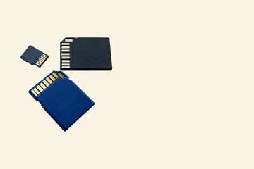 Close-up three memory cards lie on a beige surface. Media storage concept. Memory for gadgets and...