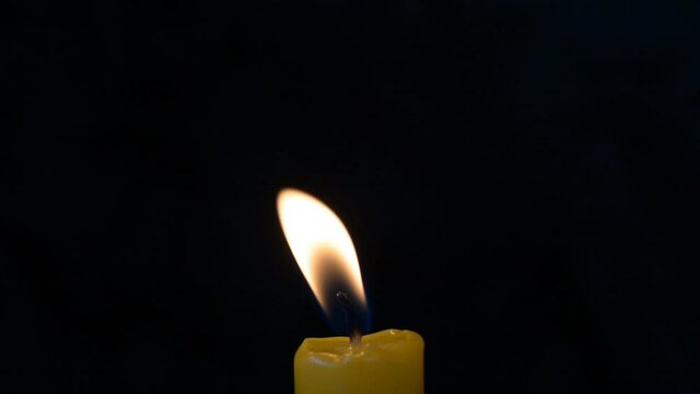 Candle flame on a black background swaying from a little wind, background, free space for text hd stock footage
