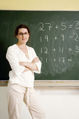 Woman standing in front of the blackboard with her arms folded