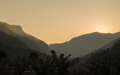 Bright sunset over tree covered mountains, Annapurna circuit, Nepal