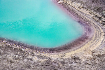 Emerald green sulfur acid lake and toxic gas at the bottom of active volcano crater, Kawah Ijen, East Java, Indonesia