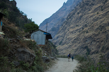 Father and son on a dirt road by beautiful mountain village, Annapurna circuit, Nepal