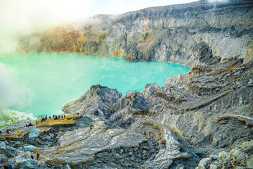 Emerald green sulfur acid lake and toxic gas at the bottom of active volcano crater, Kawah Ijen, East Java, Indonesia