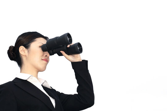 Businesswoman looking through binoculars