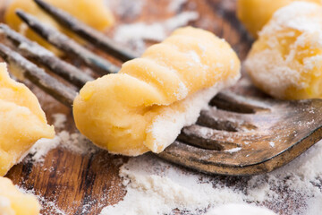 Uncooked homemade potato gnocchi with fork