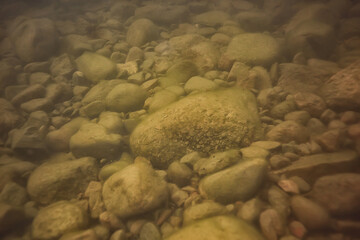 stones at the bottom underwater landscape, abstract blurred under water background